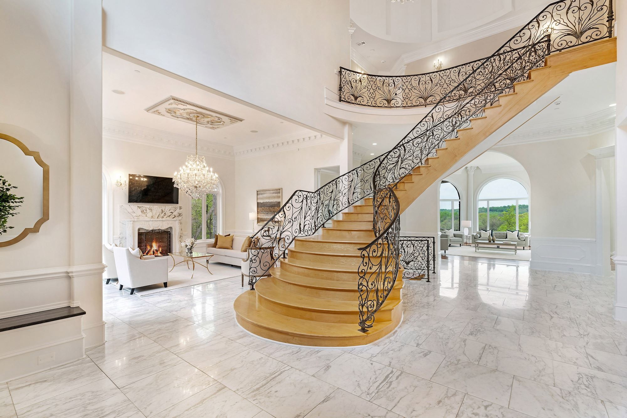 Grand foyer with curved maple staircase and marble floor