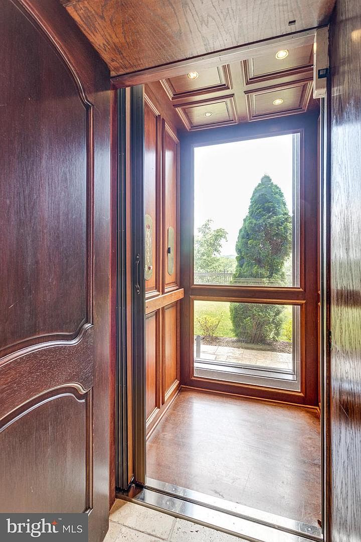 Wood-paneled elevator interior with a full-height glazed outlook