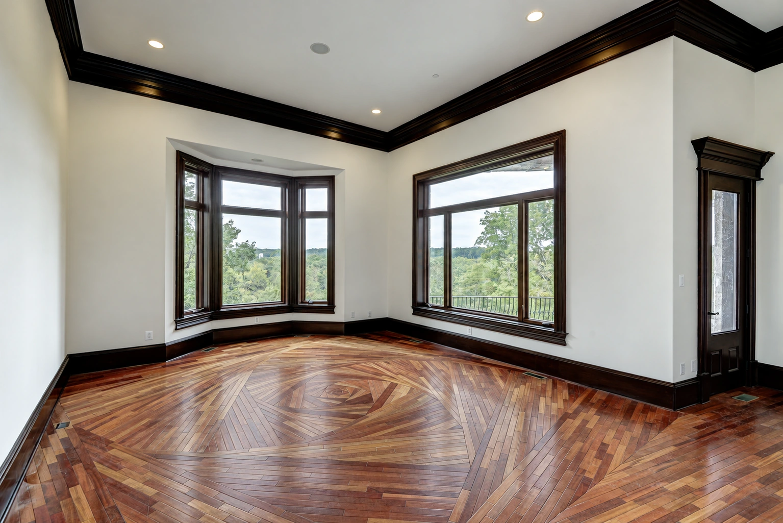The unfurnished library reveals a hardwood floor arranged in the angular, overlapping geometry of a camera shutter.