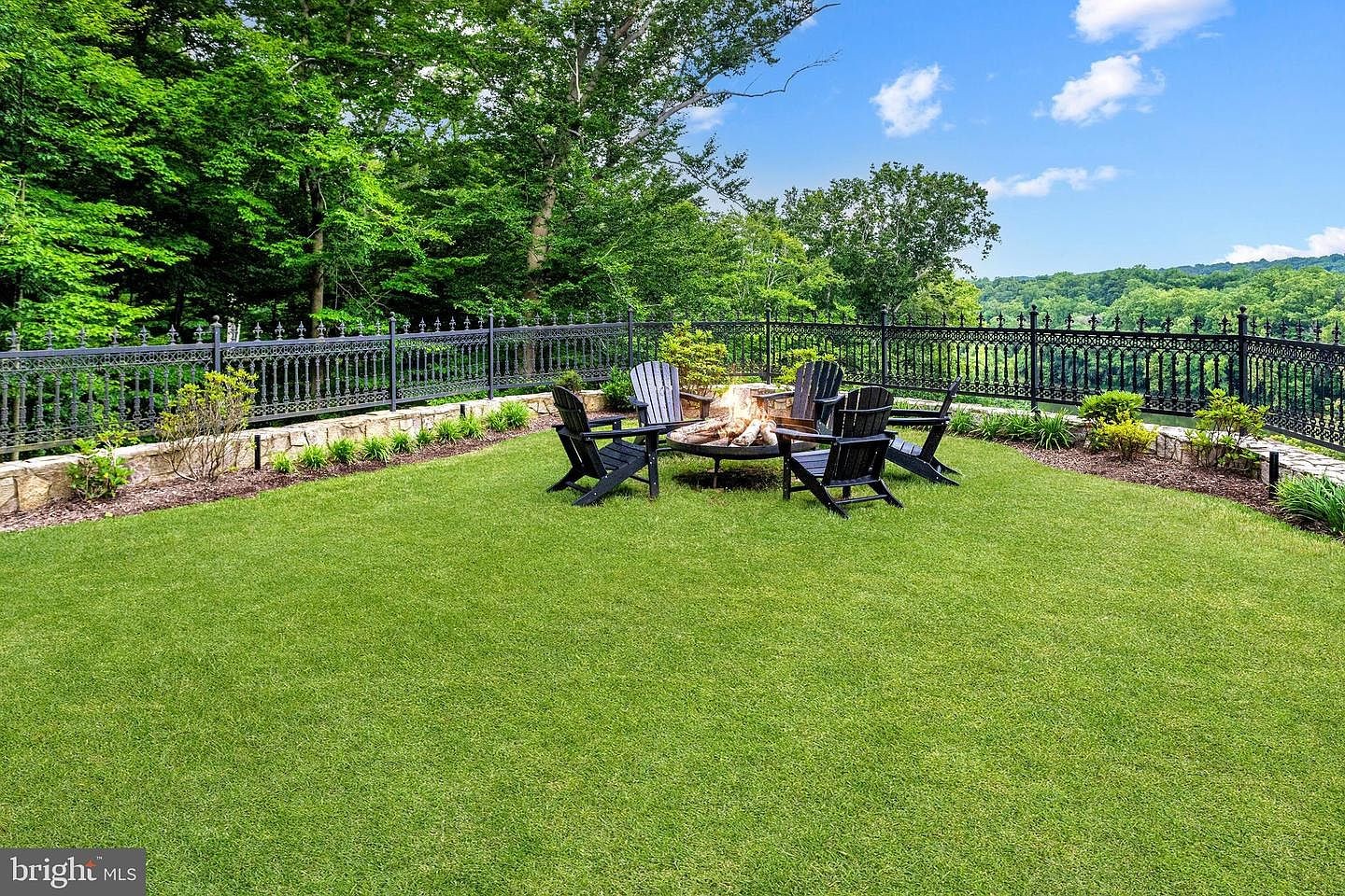 Chairs on the lawn, and the river beyond the fence.