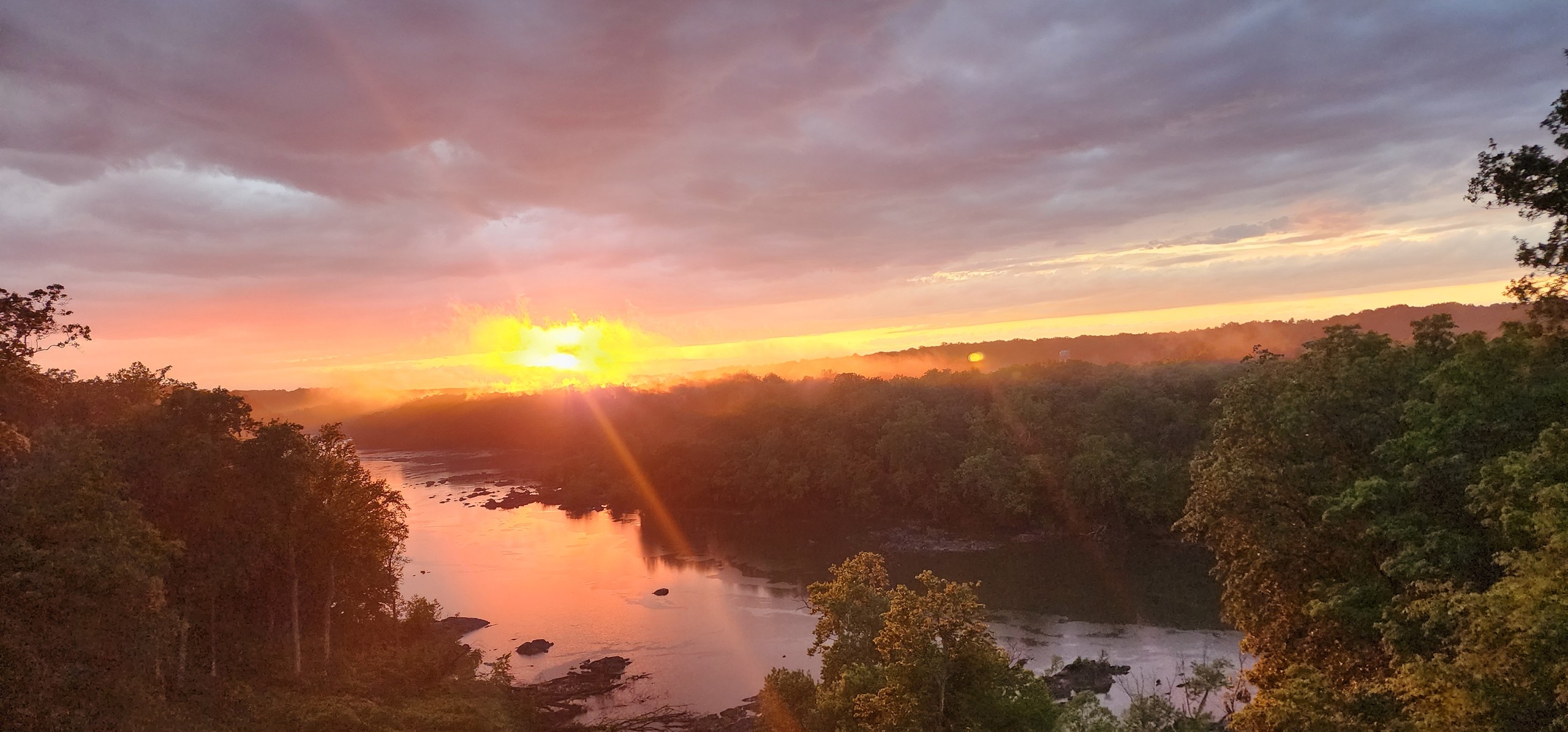 Golden evening light across the Potomac beneath pink clouds