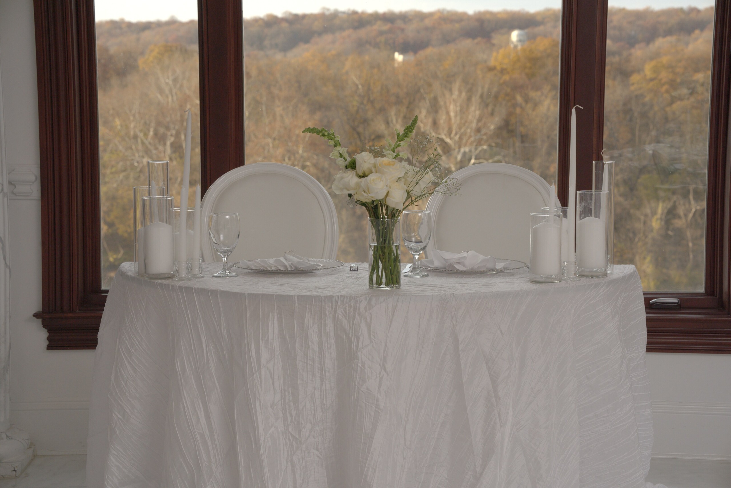 Wedding table with white flowers beside windows overlooking the Potomac