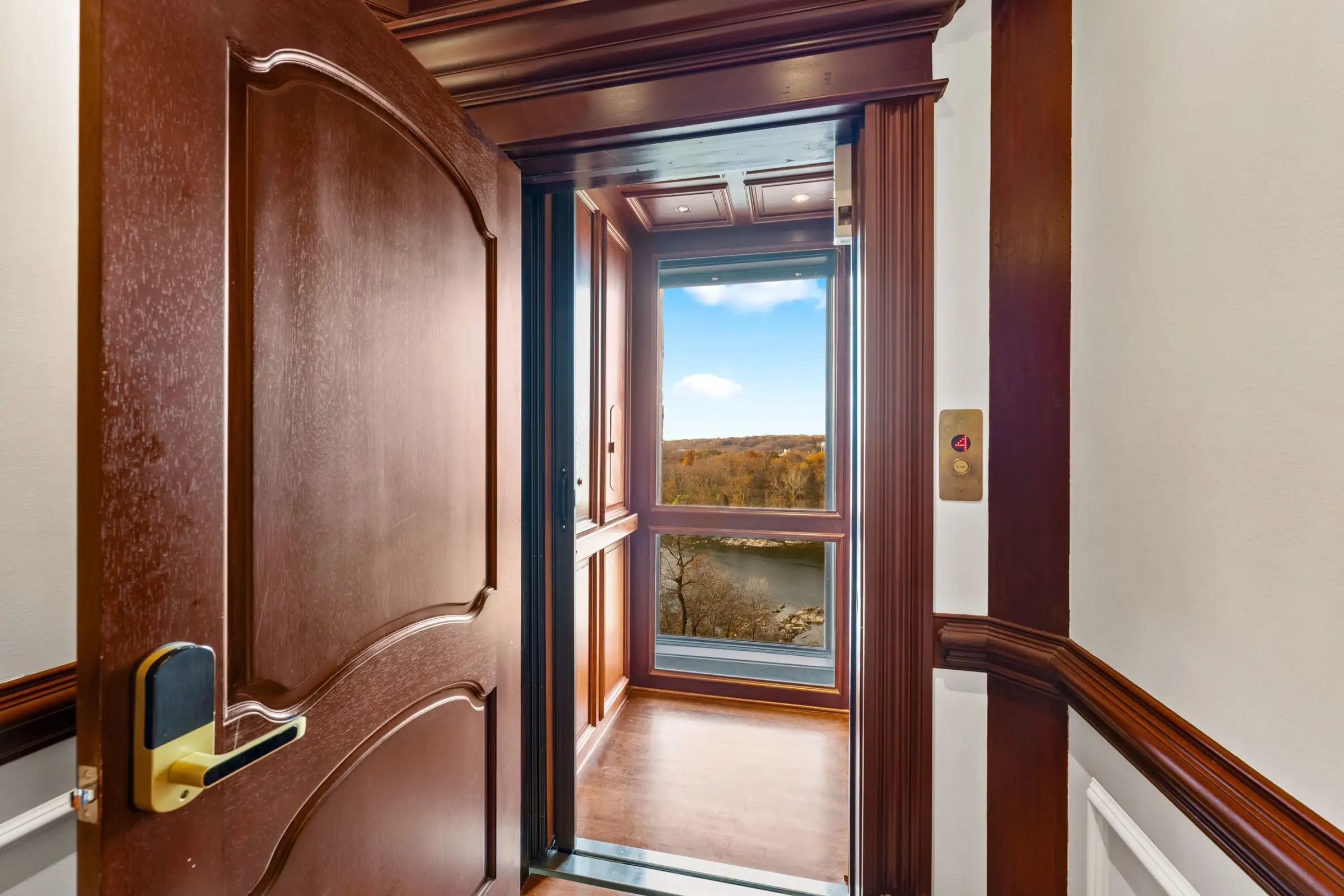 The glass elevator with its door open at the landing.