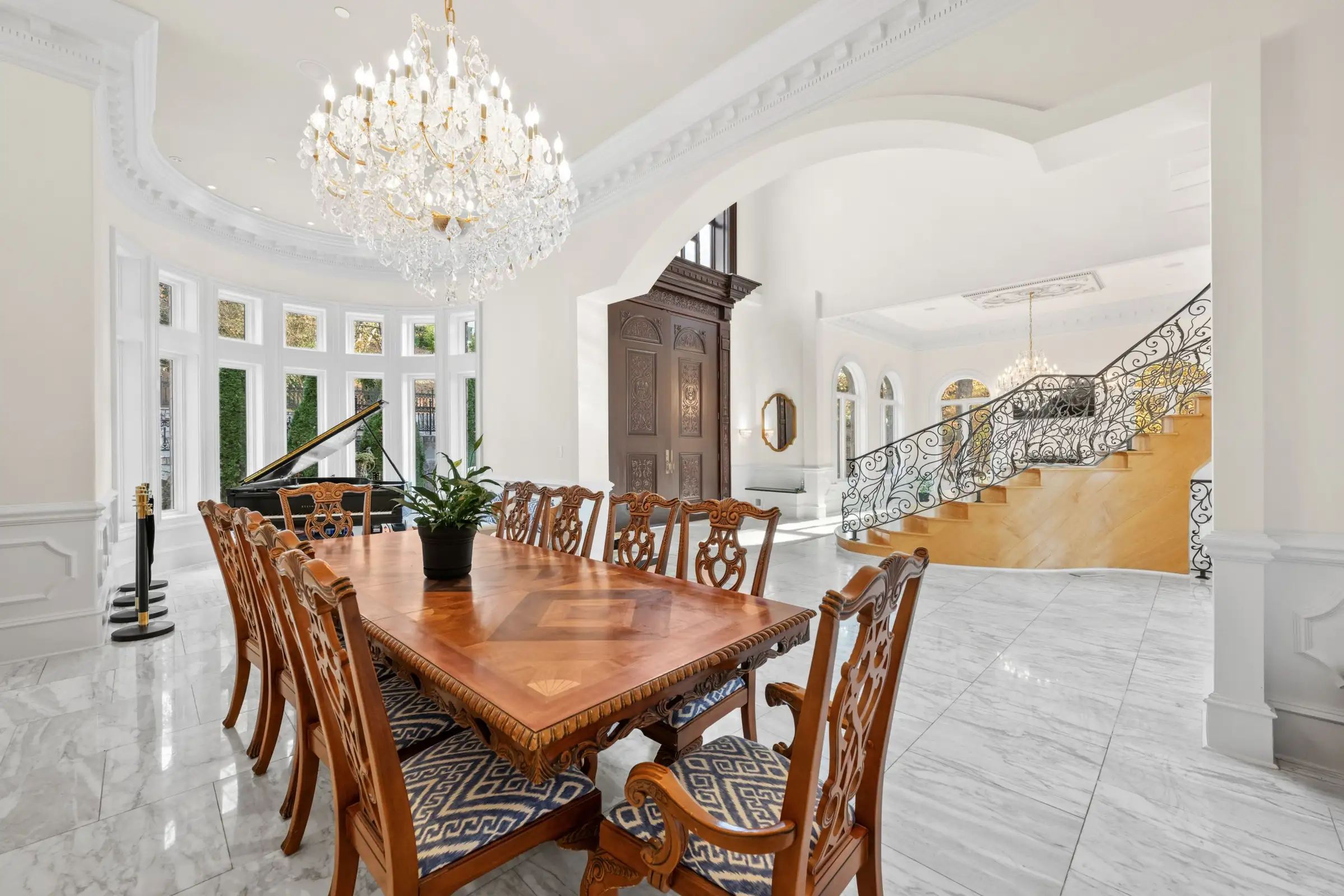 Formal dining room with piano and a view toward the grand staircase.