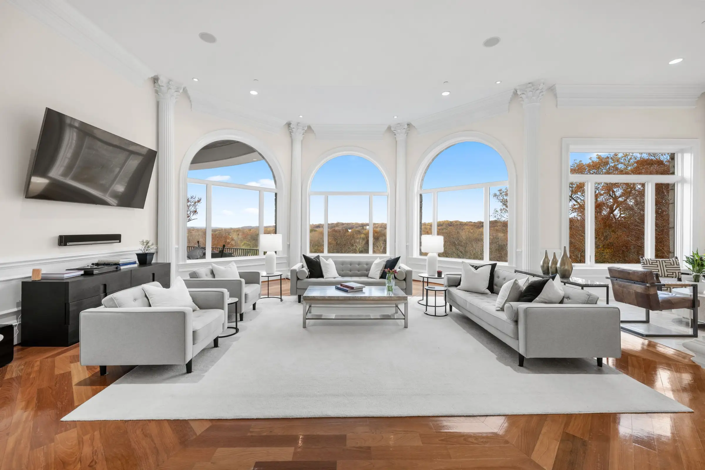 Family room beneath tall arched river-facing windows.